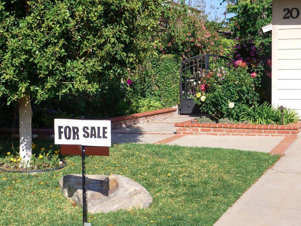 For sale sign in the front yard of an Arkansas home listed by a Resource Realty listing agent